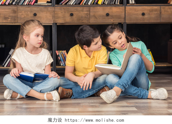 三个小孩坐在图书馆的地板上看书同学们阅读的书籍